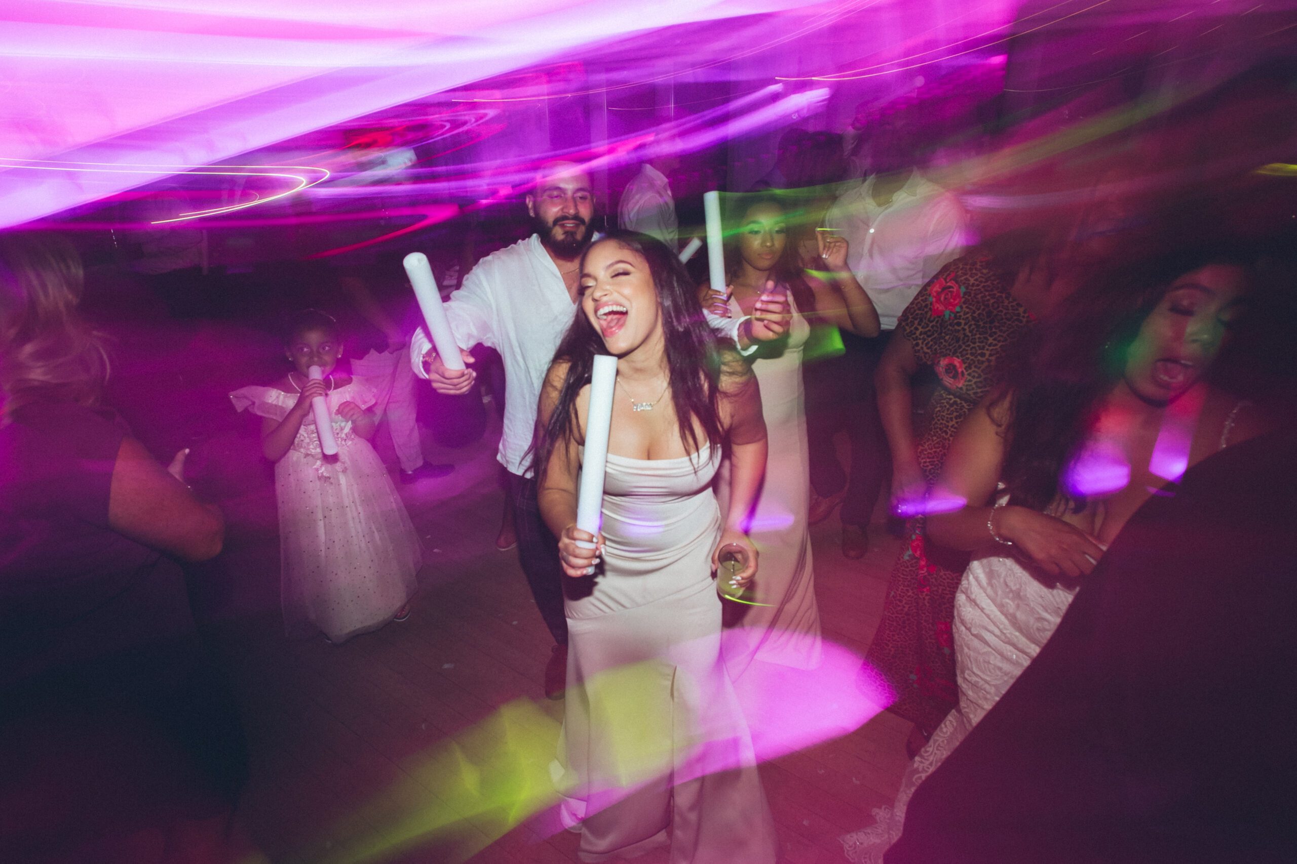 Alliee dancing with a glowing light stick as the party fills the dance floor.