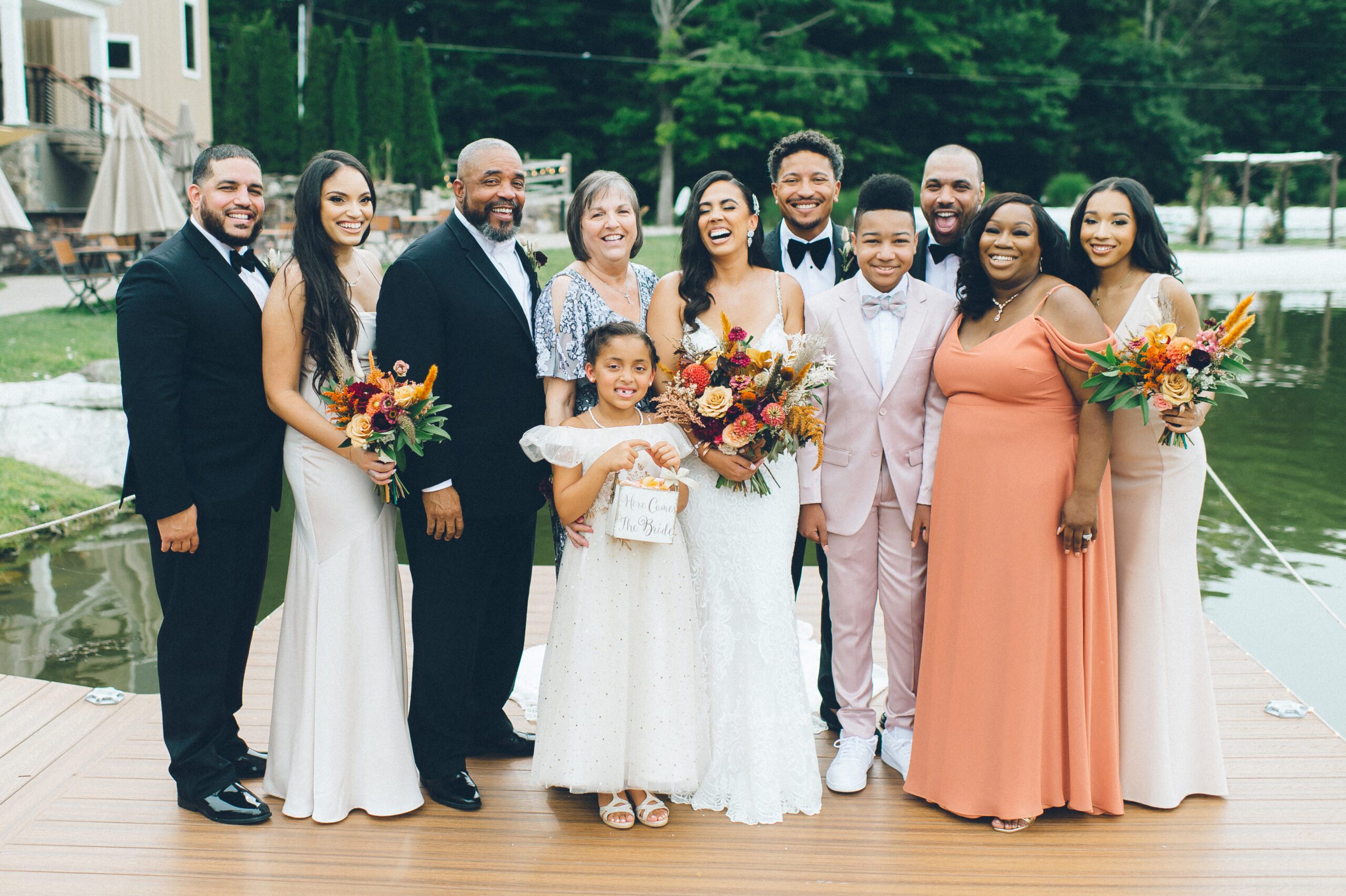 Alliee and Brandon posing with a large family group on the lakeside dock.